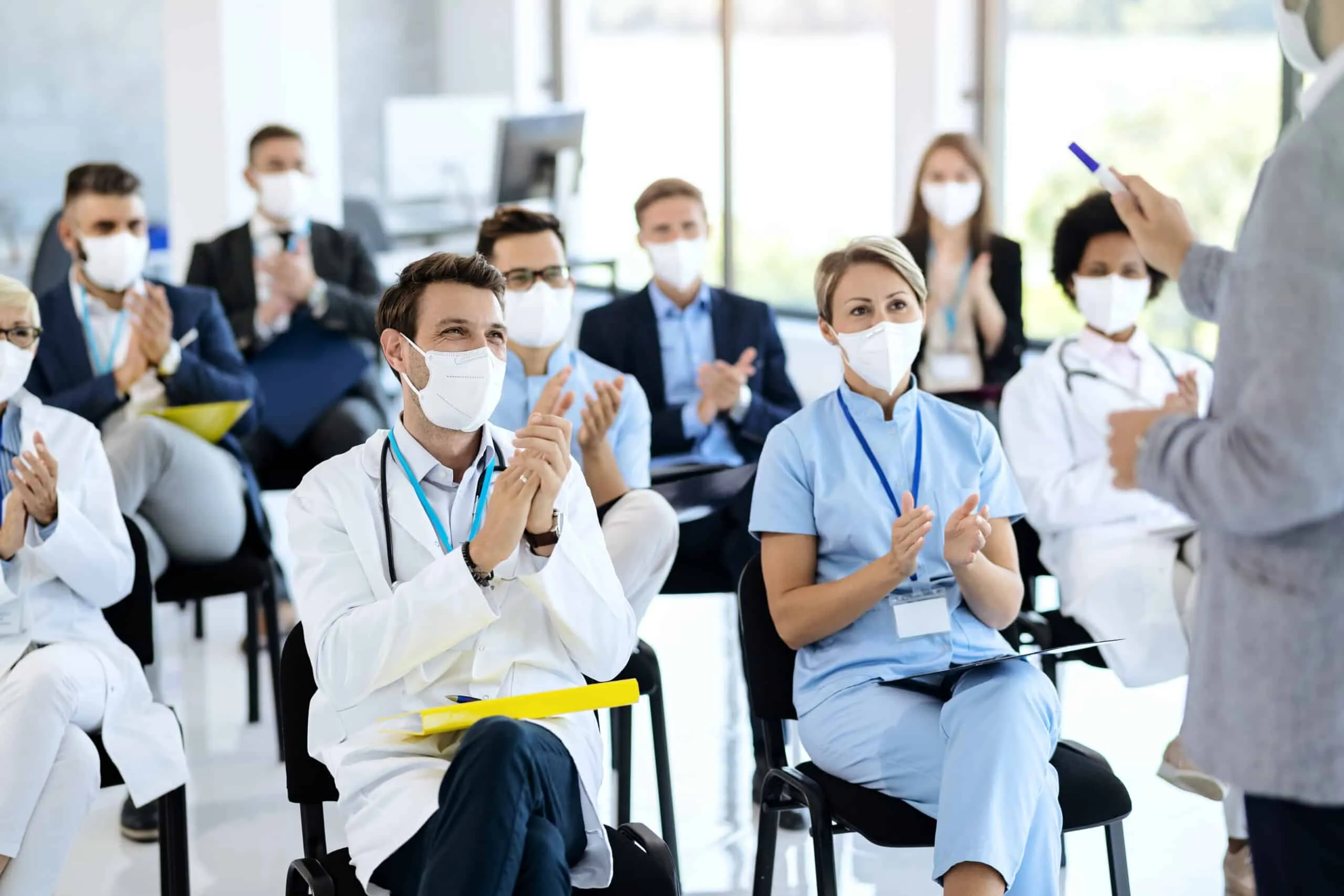 healthcare workers business people wearing face masks applauding seminar scaled 1